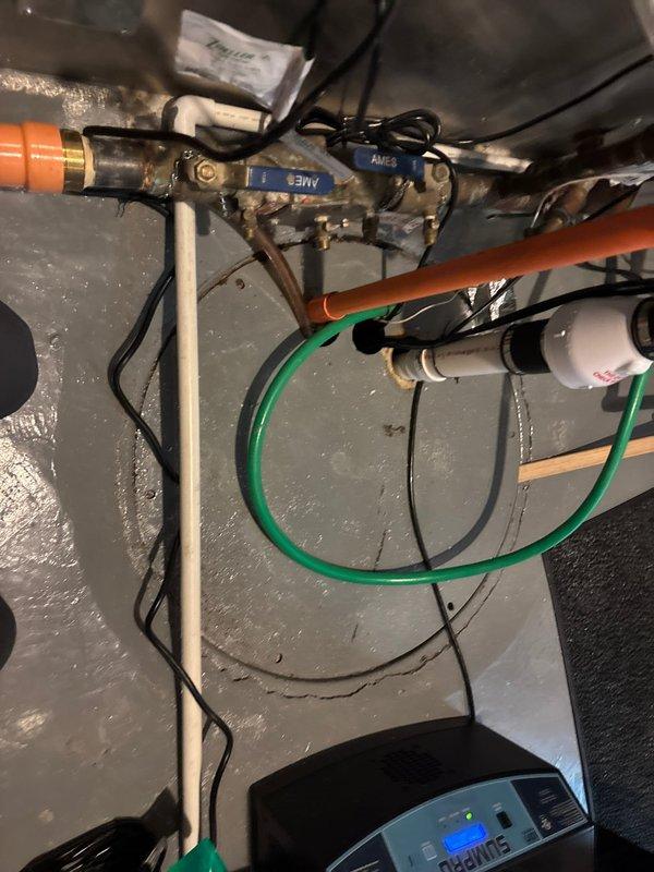 Completed installation of SumPro sump pump system with dual battery backup in basement mechanical area. Installed two new ejector pumps with associated PVC discharge piping and electrical connections, ensuring proper drainage to existing sump pit. Replaced Woodford Model 25 frost-free outdoor spigot with rebuild kit, connecting to existing copper supply lines with brass fittings and orange PEX tubing. All plumbing connections tested and verified operational with no leaks detected.