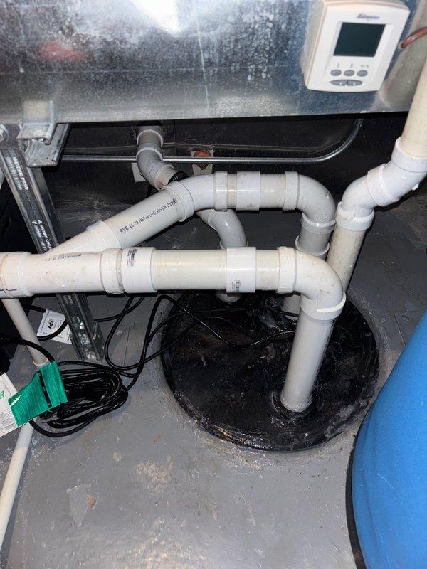 Completed installation of SumPro sump pump system with dual battery backup in basement mechanical area. Installed two new ejector pumps with associated PVC discharge piping and electrical connections, ensuring proper drainage to existing sump pit. Replaced Woodford Model 25 frost-free outdoor spigot with rebuild kit, connecting to existing copper supply lines with brass fittings and orange PEX tubing. All plumbing connections tested and verified operational with no leaks detected.