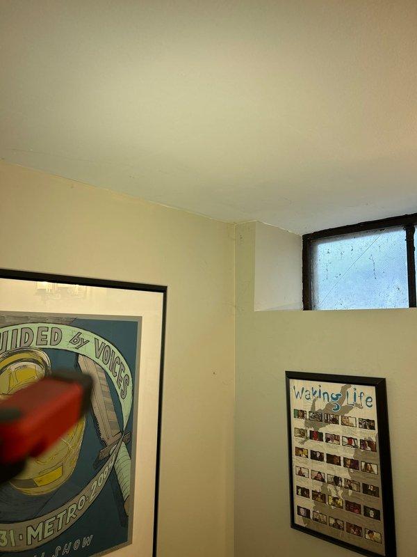 Installed new Prier outdoor frost-free spigot with quarter-turn shut-off valve featuring copper pipe connection and brass threaded fitting. The valve assembly was positioned in an interior wall location for freeze protection, with installation point accessible from inside the residence near decorative wall hangings and a small window opening.