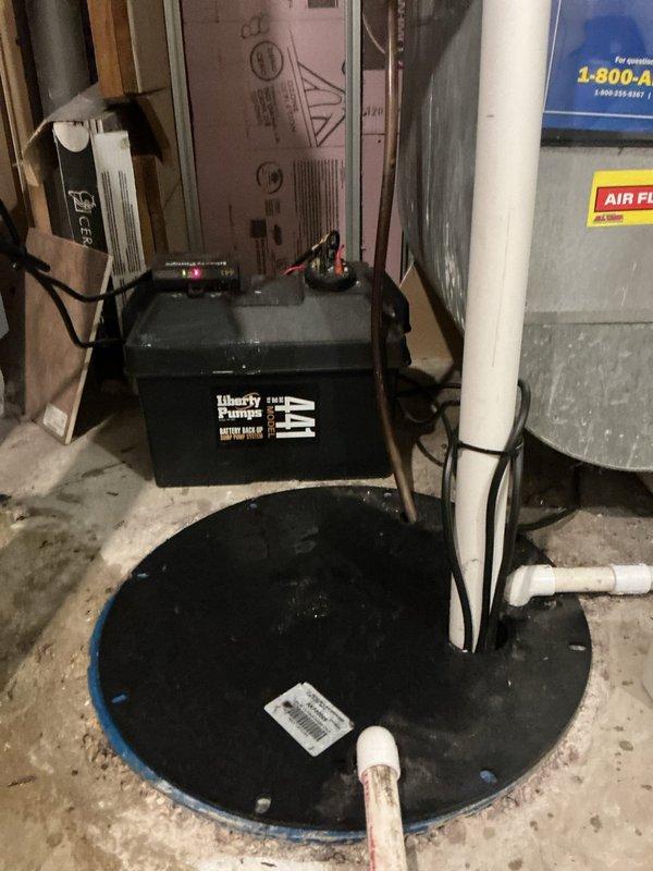 Responded to service call for sump pump check valve producing loud knocking sound. Inspected Liberty Pumps sump pump system and associated plumbing components, identifying check valve as source of water hammer noise. Performed VIP maintenance on water heater, including inspection of gas control valve, venting system, and all plumbing connections. Documented equipment conditions with photos showing sump pump basin, discharge piping, and water heater installation in basement utility area.