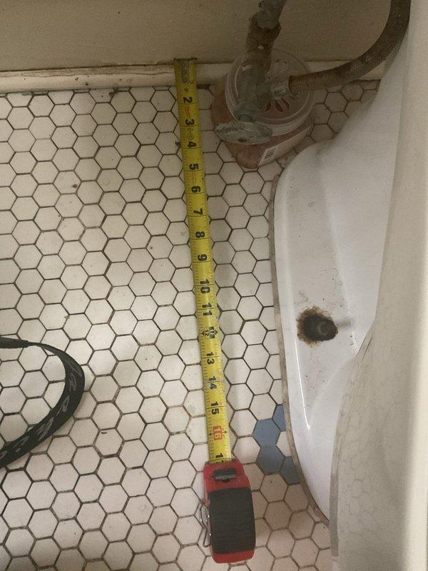 Performed inspection and assessment of toilet fixture experiencing water quality issues and deterioration. Found significant mineral deposit buildup and staining throughout toilet tank interior, affecting flush valve assembly and fill valve mechanisms. Documented extensive brown discoloration on ceramic surfaces indicating hard water deposits and age-related wear. Identified mold and mildew growth along grout lines where tank meets wall, suggesting ongoing moisture infiltration issues. Examined supply line connections and measured clearances for potential fixture replacement considerations. Photographed existing conditions including corroded components, stained porcelain surfaces, and compromised sealing areas for maintenance records and future reference.