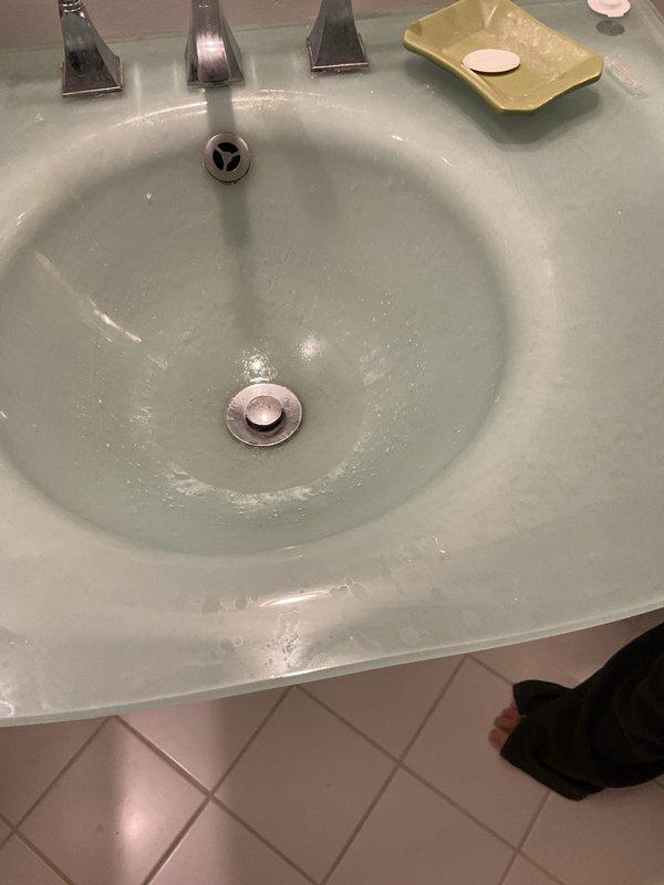 Responded to priority service call for malfunctioning toilet with broken internal components. Upon inspection, identified failed flapper valve and deteriorated fill valve assembly with significant mineral buildup and hard water deposits throughout tank interior. Replaced defective flapper valve and chain assembly, installed new fill valve with adjustable float mechanism, and adjusted water level to manufacturer specifications. Tested flush cycle multiple times to ensure proper operation and verify no leaks. Addressed customer's concerns regarding slow draining issues and recommended evaluation of main drain line for potential blockage or root intrusion, particularly given correlation with recent rainfall events.