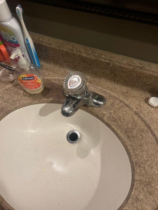 Responded to priority service call for recurring water leak from bathtub causing ceiling damage in room below. Inspected bathroom fixtures and plumbing connections to identify source of persistent leak that had required multiple previous service visits. Replaced old handles on two Kohler toilets as part of comprehensive fixture maintenance. Documented existing conditions with photographs showing bathroom vanity area and toilet installations with visible plumbing components and shut-off valves.