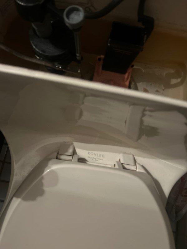 Responded to priority service call for recurring water leak from bathtub causing ceiling damage in room below. Inspected bathroom fixtures and plumbing connections to identify source of persistent leak that had required multiple previous service visits. Replaced old handles on two Kohler toilets as part of comprehensive fixture maintenance. Documented existing conditions with photographs showing bathroom vanity area and toilet installations with visible plumbing components and shut-off valves.
