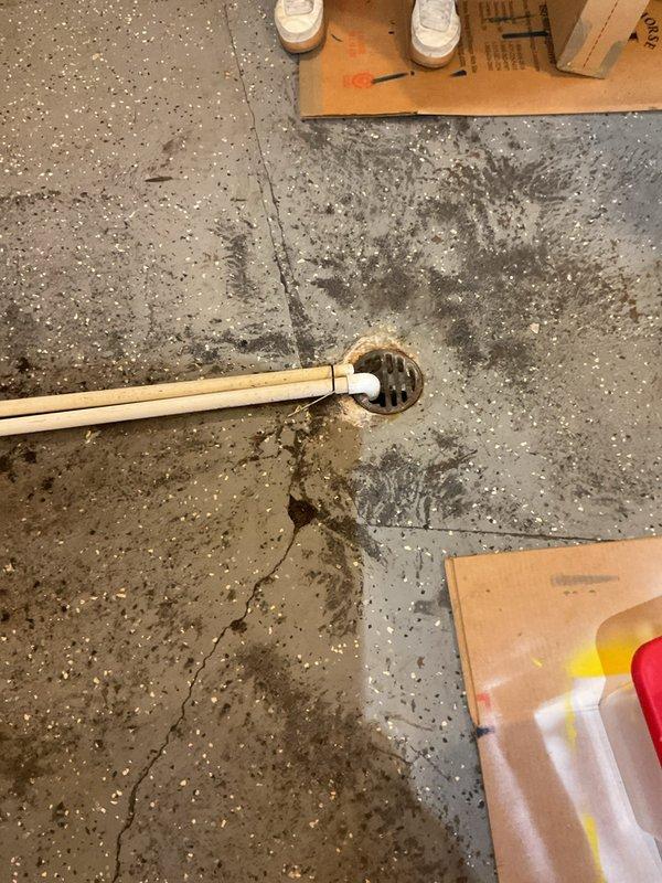 Performed video camera inspection of floor drain system experiencing water backup and pooling issues. Documented extensive water accumulation on concrete floor surrounding drain opening, indicating potential blockage or drainage system compromise. Captured visual evidence of drain condition and water damage patterns for diagnostic evaluation and customer records.