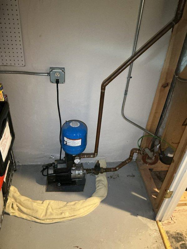 Completed residential drain and sewer estimate involving assessment of existing basement utility systems. Documented water pump system with pressure tank, associated copper piping infrastructure, and DuraMAC motorized burner unit to provide comprehensive evaluation for potential service needs.