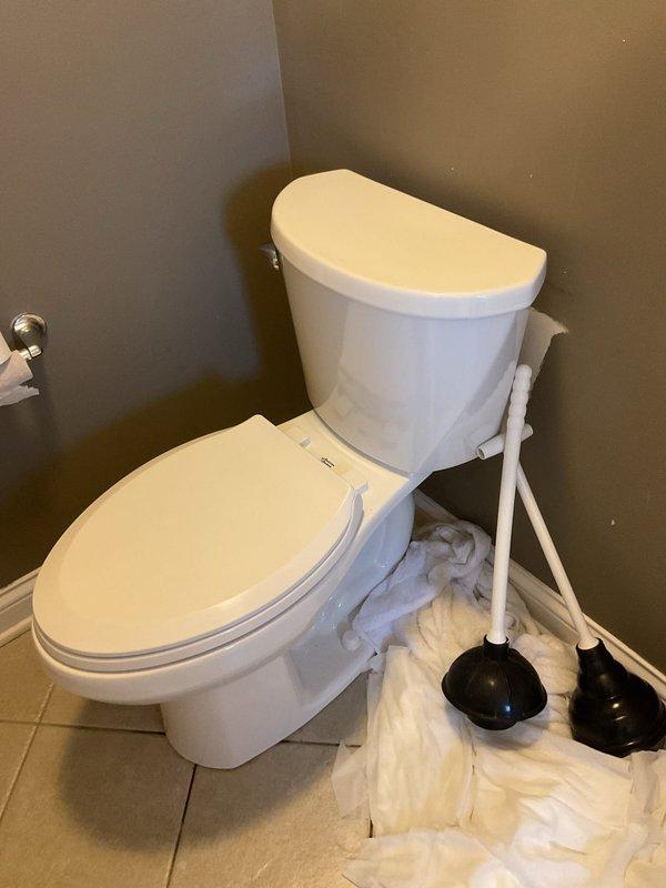 Responded to a plugged toilet in the basement of a 20-year-old home. Upon arrival, removed the toilet to access the flange and investigate the blockage. Cleared the obstruction and inspected the toilet flange, which showed signs of age, water staining, and deterioration around the seal area. Reinstalled the toilet with protective materials placed around the work area to maintain cleanliness. Tested the toilet for proper flush operation and verified drainage was restored to normal function.