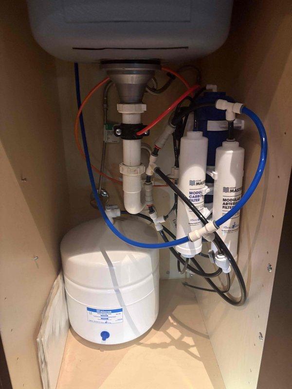 Evaluated existing under-sink reverse osmosis system with pressurized storage tank and dual-stage filtration cartridges, providing consultation on tankless RO upgrade options requiring electrical outlet installation. Inspected toilet with discolored tank water indicating rust or sediment contamination, discussed flange and subfloor repair requirements as separate scope items from standard toilet replacement, and reviewed considerations for selecting appropriate replacement toilet fixture including bowl height, flush mechanism efficiency, and rough-in measurements.