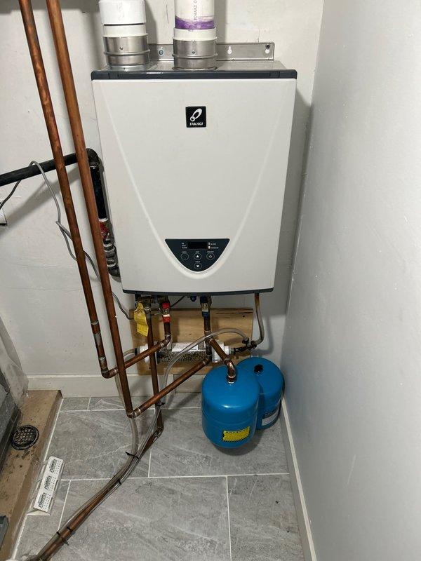 Performed water heater maintenance service on wall-mounted tankless unit and installed water supply line connection for new refrigerator. Inspected tankless water heater installation, verified proper operation of control panel and digital display, checked copper supply piping and shut-off valves, and confirmed expansion tank functionality. Connected and tested new refrigerator water line to ensure proper water flow and leak-free operation.