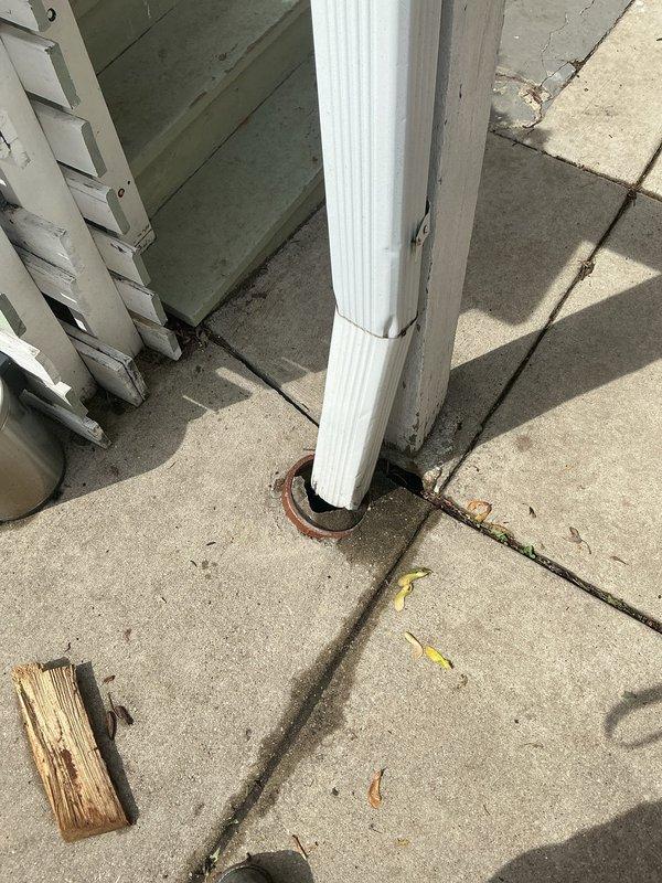 Conducted comprehensive assessment of residential drain and sewer system requiring multiple cleanout repairs. Evaluated existing cleanout access point showing significant corrosion and weathering, with oxidation and patina buildup affecting functionality. Inspected gutter drainage line connected to downspout system where concrete encasement was observed causing blockage concerns. Identified capped gutter drain line requiring potential excavation and repair work. Documented conditions of metal drain fittings embedded in concrete surfaces, noting deterioration and potential access limitations for future maintenance.