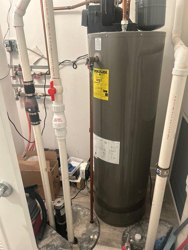 Completed plumbing estimate and inspection of residential piping system including water heater installation with copper and PVC connections. Assessed mechanical room configuration featuring water heater with copper supply lines, PVC drainage system with ball valves, and green flow control device with brass fittings integrated into the existing plumbing infrastructure.