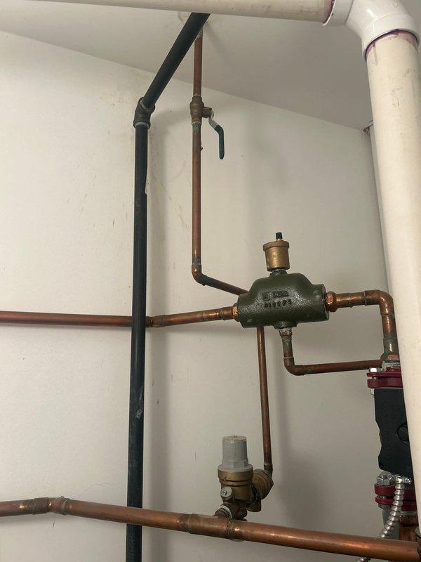 Completed plumbing estimate and inspection of residential piping system including water heater installation with copper and PVC connections. Assessed mechanical room configuration featuring water heater with copper supply lines, PVC drainage system with ball valves, and green flow control device with brass fittings integrated into the existing plumbing infrastructure.