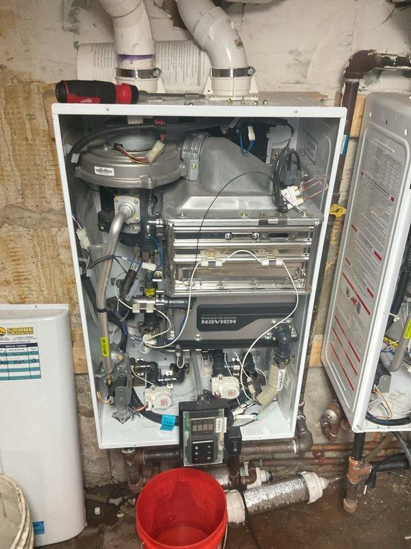 Responded to priority service call for tankless water heater system failure with error code indication and reported water leak. Inspected both Navien tankless units previously installed at property and diagnosed malfunctioning heat exchanger and burner assembly on primary unit. Performed complete system diagnostics, identified leak source at heat exchanger connections, and completed necessary repairs to restore hot water service. Unit tested and verified operational with proper venting and combustion parameters.