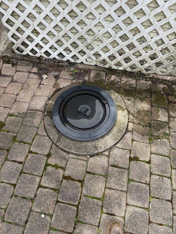 Responded to priority commercial water pressure issue caused by deteriorated galvanized piping. Accessed main water line through exterior ground-level cleanout port in paved patio area to assess flow restriction. Documented existing conditions of access point and surrounding infrastructure, noting significant mineral buildup and corrosion consistent with aged galvanized pipe systems that restrict water flow over time.