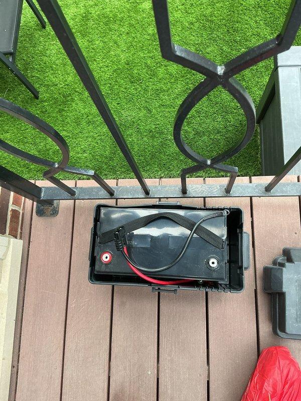 Responded to warranty inquiry regarding previously replaced battery backup system that triggered carbon monoxide detectors. Upon inspection, located battery backup unit in mechanical room connected to plumbing system with PVC piping and shut-off valves. Evaluated backup power supply unit and associated electrical connections for proper operation. Inspected external battery box on deck area, confirming battery installation and cable connections to positive and negative terminals. Documented equipment condition and configuration with photographs for warranty assessment purposes.