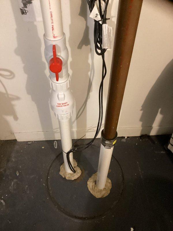 Responded to service call for rattling noise in plumbing pipes throughout the residence. Conducted thorough inspection of accessible plumbing system including bathroom fixtures and basement piping installation. Examined toilet installation, water supply lines, and drainage system in bathroom area with marble tile flooring. Inspected basement plumbing configuration including white PVC drainage pipes with quiet check valve assembly, copper water supply lines with mounting brackets, and pipe penetrations through concrete floor. Documented existing plumbing installation with photographic evidence for assessment purposes. Identified potential water hammer or loose pipe mounting as probable cause of rattling sounds reported by homeowner.