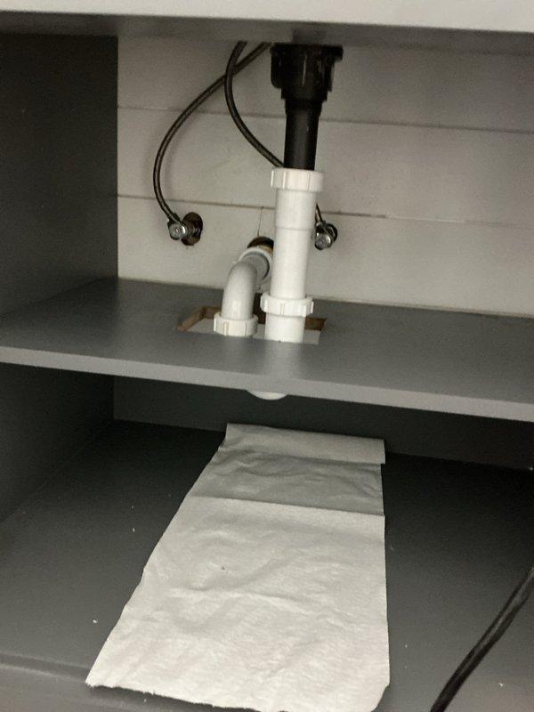 Completed installation of Kohler rectangular basin sink with matte black faucet fixture and garbage disposal unit. Configured PVC P-trap drainage system with proper venting, verified water flow and drainage functionality, and confirmed all connections are secure and leak-free under the cabinet assembly.