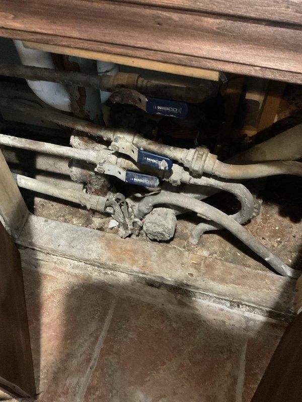 Responded to service call for malfunctioning push-type tub spout diverter that was failing to redirect water flow from tub spout to shower head. Inspected bathroom fixture assembly with brushed nickel finish mounted on marble tile surround and assessed diverter mechanism for failure points. Evaluated existing plumbing infrastructure in crawl space beneath fixture, documenting water supply lines with NIBCO valves and overall system condition to determine repair versus replacement requirements for the shower/tub valve system.