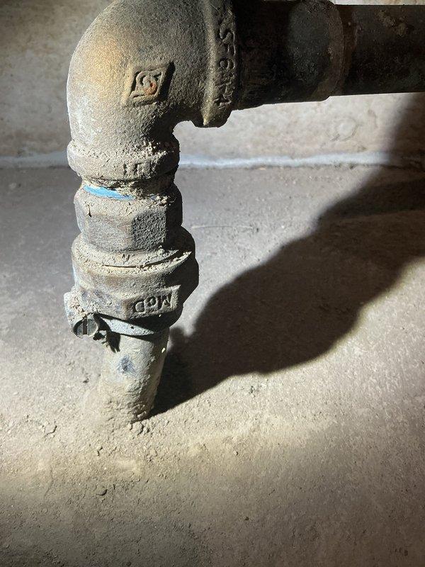 Responded to high water usage complaint with continuously running water meter. Confirmed water meter activity ceased when shutoff valve to coach house was closed, isolating leak to underground supply line between main house and coach house. Inspected basement plumbing connections and shutoff valve assembly serving coach house line. Documented condition of pipe penetration through foundation wall and valve configuration. Advised customer of suspected underground leak in buried water line to coach house, as no audible leaks detected in coach house interior and meter test confirmed issue isolated to that supply line.