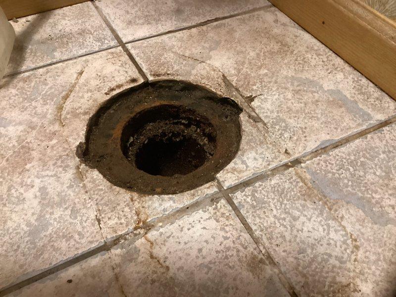 Responded to customer request for toilet flange repair at afternoon appointment. Removed existing deteriorated toilet flange that showed significant buildup of debris, grime, and sediment accumulation around the drain opening. Installed new white PVC closet flange with brass mounting brackets, securing it flush to the tiled bathroom floor. Ensured proper alignment and stable mounting preparation for future toilet reinstallation.