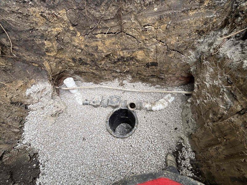 Completed installation of flood control drainage system with excavated trench and subsurface drainage components. Installed PVC piping network with junction fittings, cleanout access point, and connection to main drainage line, all properly bedded in white gravel base for optimal water permeation and system stability. Financing was approved and appointment scheduled for final inspection.