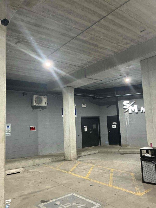 Responded to service call back at underground parking garage level near commercial tenant space. Documented existing conditions for estimate preparation, including overhead plumbing infrastructure, exposed concrete ceiling with visible utilities, and building mechanical systems. Photographed parking area layout, structural columns, wall-mounted HVAC equipment, and utility routing for comprehensive assessment and proposal development.