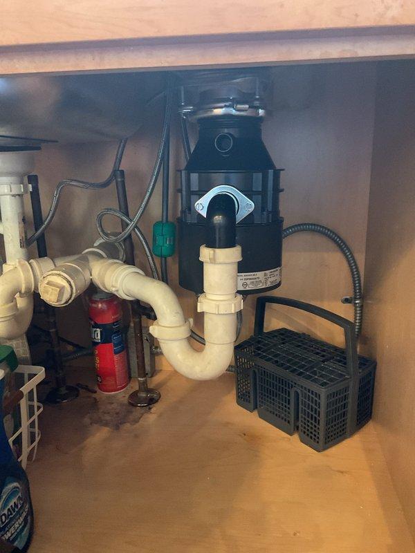 Completed installation of garbage disposal unit under kitchen sink with proper PVC P-trap drainage configuration. Verified electrical circuit breaker connection and labeling in main service panel for disposal unit. Follow-up appointment scheduled to complete remaining fixture work with additional technician support.