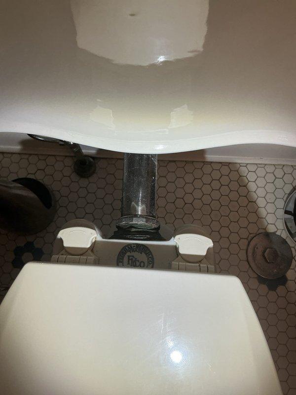 Responded to service call for downstairs toilet experiencing slow drainage and incomplete flushing. Upon arrival, confirmed that fixture had been previously plunged and snaked with no visible obstruction found, yet continued to exhibit sluggish flow, particularly when toilet paper was present. Conducted thorough diagnostic inspection of the toilet bowl, trapway, and visible drainage connections. Assessed the flush mechanism, water supply line with braided connector, and shut-off valve for proper operation. Documented existing conditions including hexagonal tile flooring and fixture placement against tiled wall. Based on diagnostic findings and symptoms of persistent slow drainage without identifiable blockage in accessible areas, determined that issue likely stems from partial obstruction deeper in the drain line beyond the toilet trap or potential venting problems affecting drainage performance. Provided assessment and recommended options for resolution.