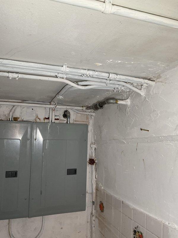 # Plumbing Service - Clogged Drain/Sink

Responded to clogged drain service call in basement utility area. Upon inspection, accessed main drain line using pipe wrench to remove cleanout plug near overhead plumbing junction. Successfully cleared obstruction from drain system and verified proper water flow. Reinstalled cleanout plug and confirmed all connections were secure with no leaks present.