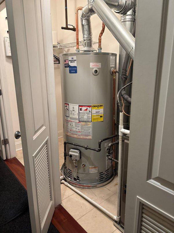 Completed installation of new residential tanked water heater in utility closet. Removed existing unit and installed replacement cylindrical tank water heater with proper venting, gas connections, and water supply lines. Connected copper water supply piping to inlet and outlet ports, installed pressure relief valve with discharge piping, and secured metallic vent pipe for proper exhaust ventilation. Configured gas control valve assembly and verified all connections for proper operation and safety compliance. Unit tested and fully operational upon completion.