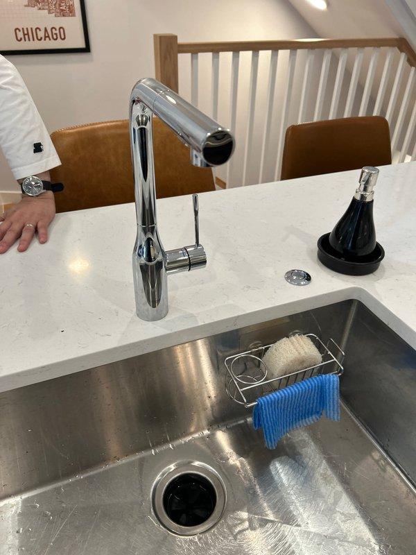 Installed new kitchen faucet with pull-down sprayer featuring contemporary chrome finish and single-lever handle operation. Completed installation with proper water supply connections and verified full functionality of the faucet assembly and spray mechanism.