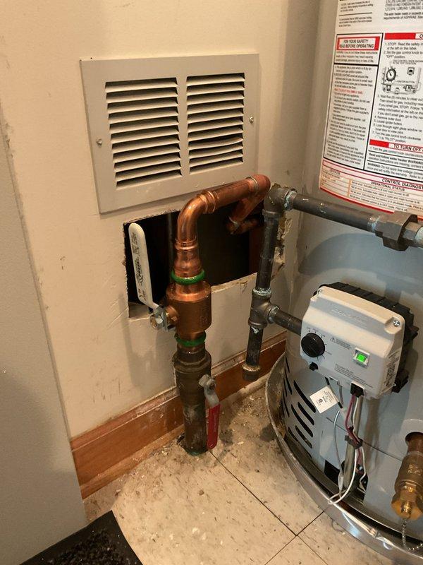 Successfully replaced the main house 1 1/2" ball valve by cutting out the existing valve assembly and freeing the copper line. Cut access opening in wall to properly unsweat the 1 1/2" brass 90-degree elbow fitting, allowing for complete removal and replacement of the valve. Installed new ball valve with compression fittings, tested system for proper operation and verified no leaks at all connection points.