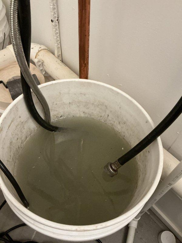 Performed comprehensive VIP maintenance service on tankless water heater system. Completed descaling flush procedure using circulation pump and cleaning solution through inlet and outlet connections, as evidenced by collection bucket setup with service hoses. Inspected all copper supply lines, brass isolation valves, and flexible connector hoses for proper operation and potential leaks. Verified electrical connections and mounting hardware integrity. System flushed thoroughly to remove mineral buildup and restore optimal heat exchanger efficiency.