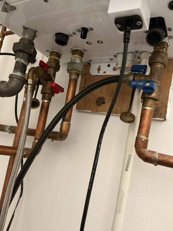 Performed comprehensive VIP maintenance service on tankless water heater system. Completed descaling flush procedure using circulation pump and cleaning solution through inlet and outlet connections, as evidenced by collection bucket setup with service hoses. Inspected all copper supply lines, brass isolation valves, and flexible connector hoses for proper operation and potential leaks. Verified electrical connections and mounting hardware integrity. System flushed thoroughly to remove mineral buildup and restore optimal heat exchanger efficiency.