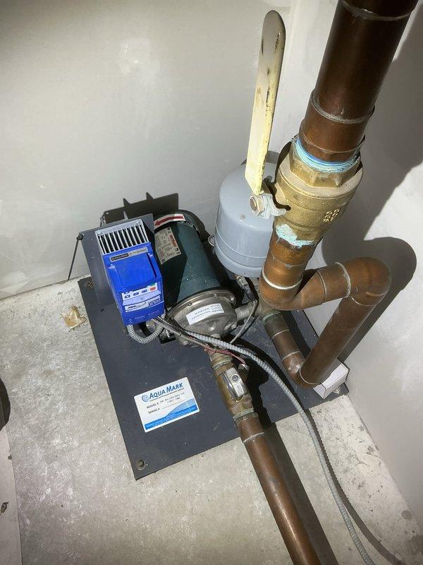 Replaced and installed new Aqua Mark water pump system in basement utility area. The installation included mounting the pump assembly on a secure base plate, connecting to existing copper piping infrastructure, installing pressure gauge for system monitoring, and completing all electrical connections with proper conduit protection. System was tested and verified operational with correct rotation direction confirmed.