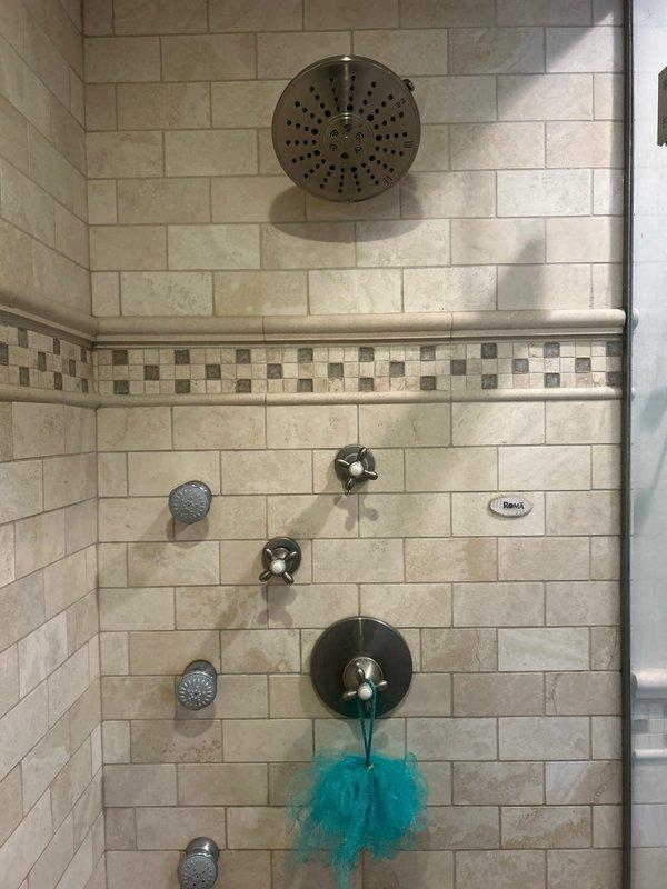Completed priority plumbing repairs in residential bathroom including replacement of bathroom faucet fixture, installation of new shower cartridge in multi-function shower system with rain head and body spray jets, and replacement of damaged ceramic sink basin. All fixtures tested and verified operational upon completion.