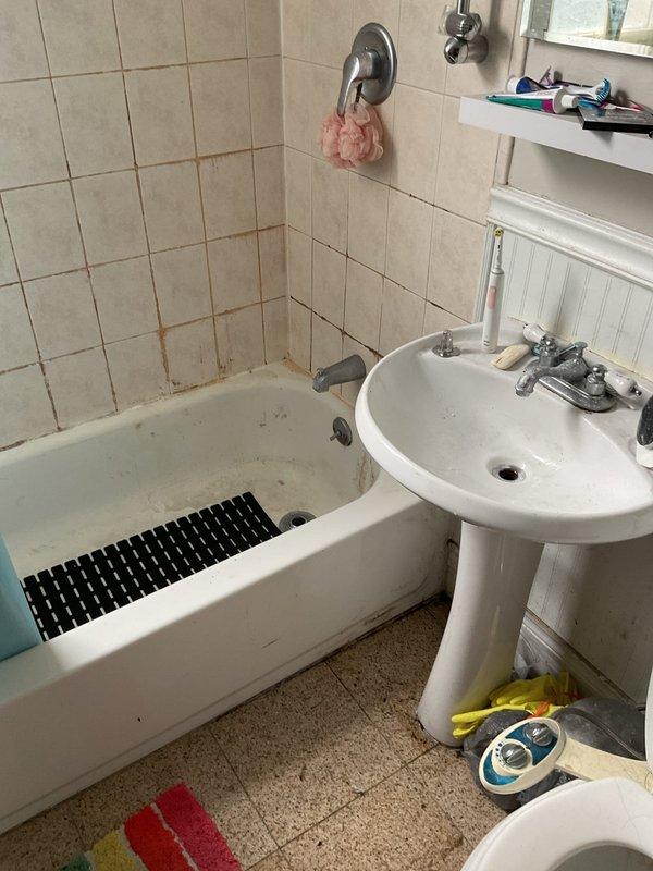 Responded to service call for clogged bathroom shower drain and sink drain. Upon arrival, inspected residential bathroom with pedestal sink and tub/shower combination showing signs of drainage issues. Accessed plumbing system through wall cavity to evaluate drain lines and identify blockage points. Located copper supply lines and drain piping behind wall access panel. Assessed condition of drain assembly connections for both fixtures. Documented existing conditions including visible water staining on tile surfaces near tub area, indicating potential chronic drainage problems. Cleared obstructions from both the shower drain line and sink drain line to restore proper water flow. Verified drainage functionality of both fixtures upon completion. Provided estimate for any additional repairs needed to address underlying plumbing concerns.