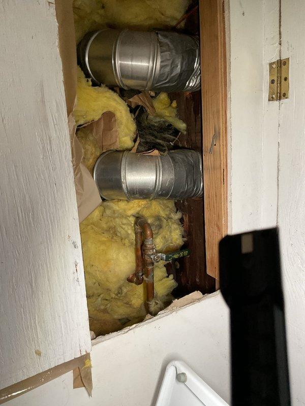 Responded to service call for clogged bathroom shower drain and sink drain. Upon arrival, inspected residential bathroom with pedestal sink and tub/shower combination showing signs of drainage issues. Accessed plumbing system through wall cavity to evaluate drain lines and identify blockage points. Located copper supply lines and drain piping behind wall access panel. Assessed condition of drain assembly connections for both fixtures. Documented existing conditions including visible water staining on tile surfaces near tub area, indicating potential chronic drainage problems. Cleared obstructions from both the shower drain line and sink drain line to restore proper water flow. Verified drainage functionality of both fixtures upon completion. Provided estimate for any additional repairs needed to address underlying plumbing concerns.