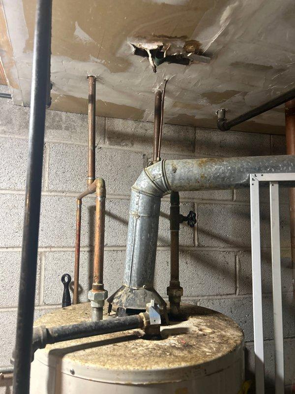 Completed installation of 50-gallon tanked water heater in basement utility area. Removed existing water heater and installed replacement unit with proper copper pipe connections, shut-off valves, and drain valve. All plumbing connections were secured and tested for leaks to ensure proper operation of the new system.