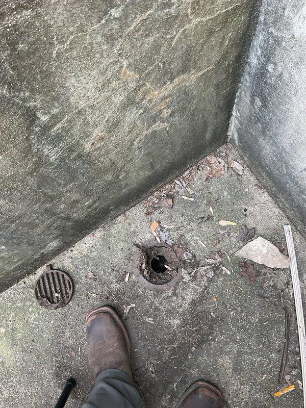Responded to complaints of sewer odor and water backup affecting basement toilet and bathtub, with sump pump running continuously following recent heavy rainfall. Performed rodding service on clogged floor drain located near back door exterior, removing accumulated debris including leaves and organic matter from drain grate and line. Inspected basement plumbing system including vertical PVC drain lines and sump pump operation to identify source of backup and verify proper drainage function was restored.