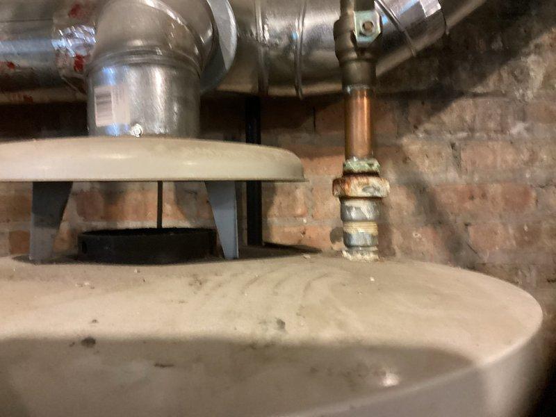 Completed comprehensive plumbing maintenance inspection of basement utility area, including evaluation of aging galvanized pipe assembly and shutoff valve system. Documented existing moisture damage, wall deterioration, and condition of mechanical equipment including water heating components and associated copper piping with shutoff valves for maintenance records and future service planning.