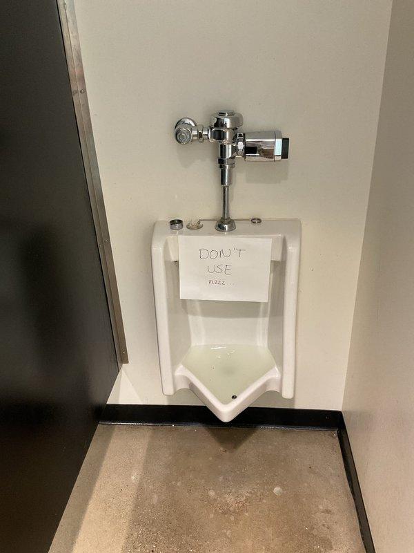 Responded to commercial facility for clogged men's urinal that was not draining despite previous attempts with plunger and chemical drain cleaner. Upon arrival, found urinal tagged out of service. Performed drain clearing service using professional equipment to remove obstruction from urinal drain line. Restored proper drainage and flushing function to fixture, returning unit to normal operation.