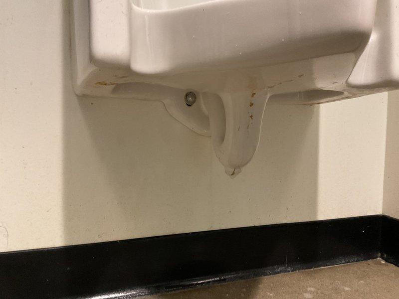 Responded to commercial facility for clogged men's urinal that was not draining despite previous attempts with plunger and chemical drain cleaner. Upon arrival, found urinal tagged out of service. Performed drain clearing service using professional equipment to remove obstruction from urinal drain line. Restored proper drainage and flushing function to fixture, returning unit to normal operation.