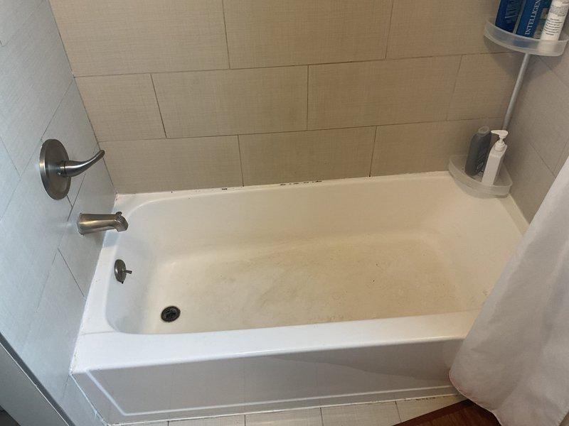 Completed installation of brushed nickel tub and shower fixtures in residential bathroom with tiled surround. Installed combination tub spout, shower control valve, and showerhead on tiled walls, ensuring proper alignment and water-tight connections. All fixtures tested and confirmed operational with no leaks detected.
