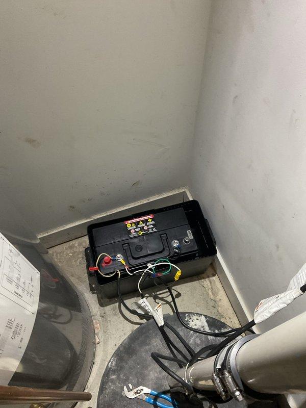 Responded to service call for non-functional sump pump backup battery system following recent power outage. Upon arrival, inspected downstairs utility space and confirmed backup battery failure in 20-year-old residential sump pump installation. 

Disconnected existing automotive-style battery from system, removing corroded terminal connections and associated wiring harnesses. Verified sump pump primary operation and float switch functionality. Installed new replacement backup battery per customer request, reconnecting all power cables and terminal rings to proper polarity. Tested battery charging circuit and verified system integration with existing sump pump controller. Confirmed backup power system now operational and ready for next power interruption event.