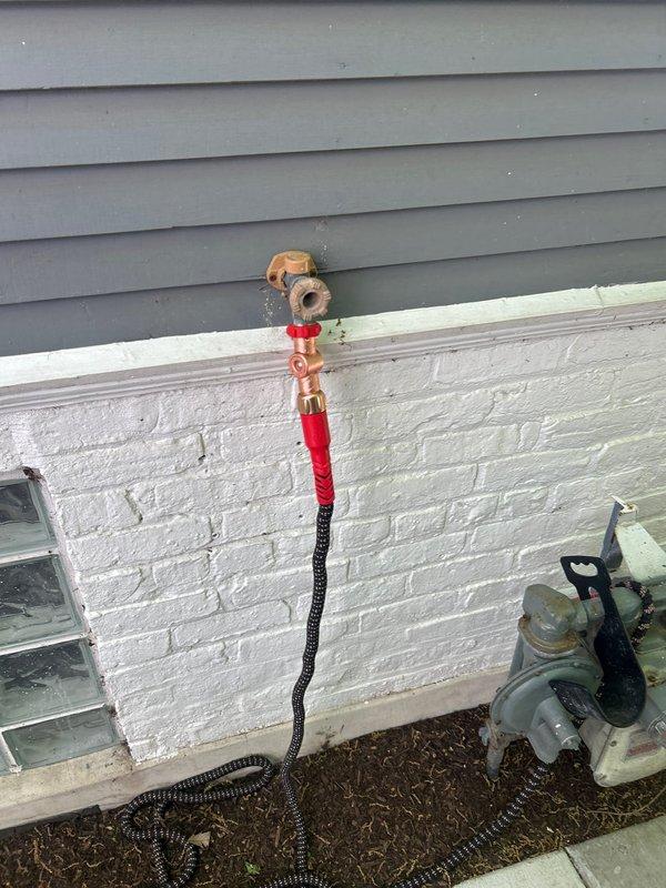 Replaced failed outdoor hose spigot that was leaking and not delivering water flow when hose was connected, damage likely caused by freeze conditions from previous winter. Accessed supply line through interior ceiling, installed new frost-free sillcock with proper insulation on exterior copper piping using red and black insulating materials, and restored full water flow to outdoor connection point.