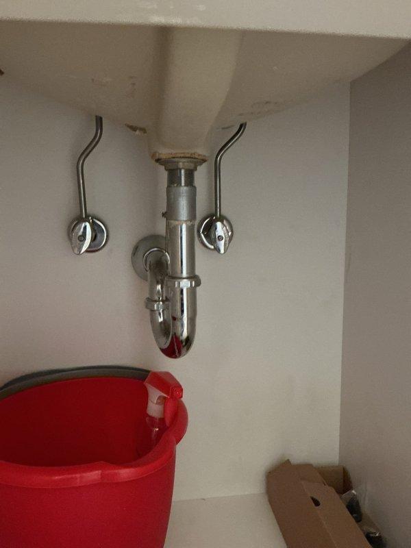 Responded to service call for faucet installation requiring two-person assistance. Upon arrival, confirmed that necessary parts were on-site and ready for installation. Assessed the existing under-sink plumbing configuration, which included a chrome P-trap assembly, supply lines, and shut-off valves in functional condition. Prepared work area by placing catch bucket beneath drain assembly to protect cabinetry and contain any residual water during installation process. Documented pre-installation and post-installation conditions of plumbing connections and cabinet interior. Work completed successfully with all components properly secured and tested for proper drainage and water flow.