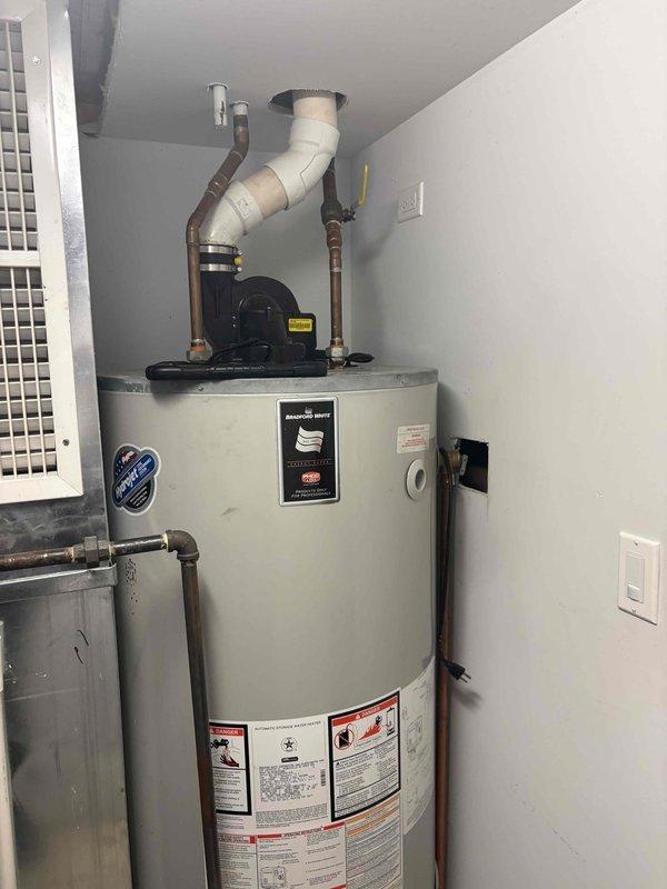 Replaced failed 75-gallon power vent water heater that was actively leaking. Shut down water supply to residence and drained existing unit completely before removal and off-site disposal. Installed new 75-gallon power vent water heater in same location with upgraded components including new 1-inch isolation valve and 3/4-inch expansion tank. Connected to existing 1-inch copper trunk lines that reduce to 3/4-inch at unit and tied into existing 1/2-inch gas piping. 

Integrated 3/4-inch recirculation line to base of unit with new 1/2-inch check valve and boiler drain. Installed isolation valves on return line to allow independent shutdown capability. Corrected improperly installed 3-inch power vent exhaust system which lacked proper primer and glue application, causing separation at ceiling connection point. Completely repiped 3-inch exhaust from ceiling penetration with proper materials and installation techniques to ensure secure, code-compliant venting. Verified all connections for pr
