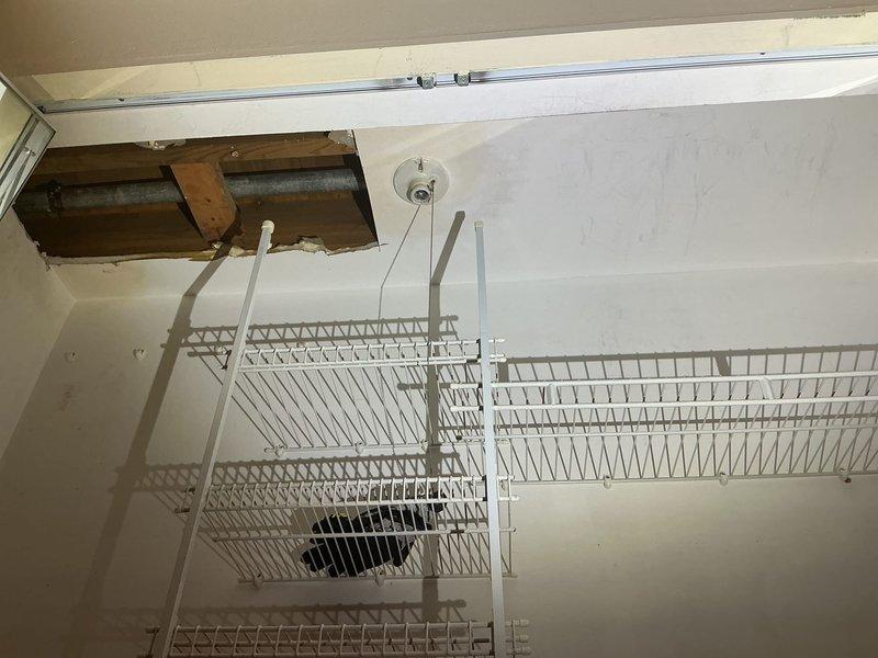 Responded to request for water service line repair affecting the entire building. Upon inspection, accessed ceiling cavity through existing opening to assess the main water supply pipe servicing the structure. Documented galvanized piping system running through ceiling joists, identified pipe configuration and connection points, and evaluated the extent of required repairs to restore proper water service to all units.