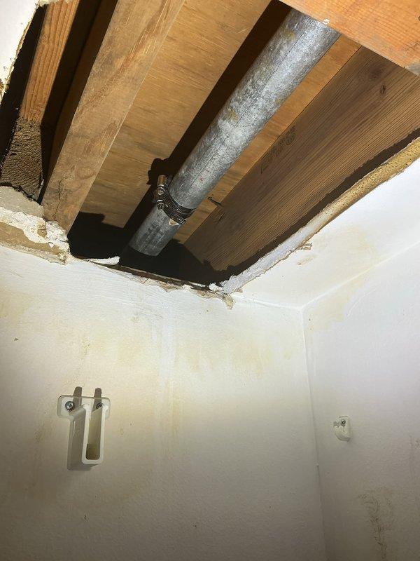 Responded to request for water service line repair affecting the entire building. Upon inspection, accessed ceiling cavity through existing opening to assess the main water supply pipe servicing the structure. Documented galvanized piping system running through ceiling joists, identified pipe configuration and connection points, and evaluated the extent of required repairs to restore proper water service to all units.
